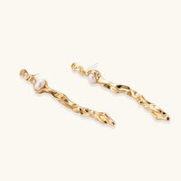 Thumbnail for Organic twisted gold-toned drop earrings with white ABS pearls positioned near the top on cream background.