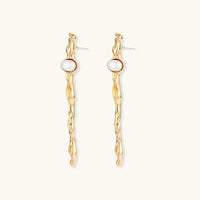 Thumbnail for Organic twisted gold-toned drop earrings with white ABS pearls positioned near the top on cream background.